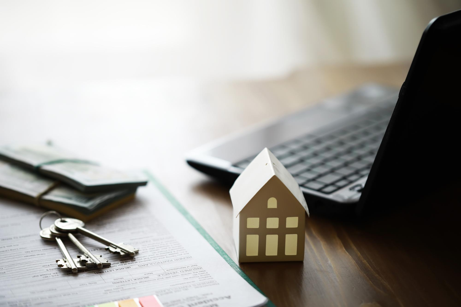 Modèle de maison avec agent immobilier et client discutant d'un contrat d'achat d'assurance habitation.